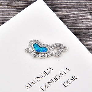Détail macro du pendentif cœur infini avec opale bleue et zircons pour bijoux DIY