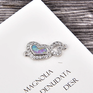 Détail macro du connecteur double cœur en argent avec opale et zircon pour bijoux DIY