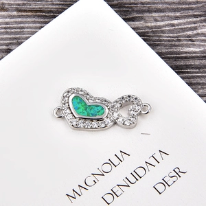 Détail macro du connecteur double cœur avec opale verte et zircons pour bijoux DIY