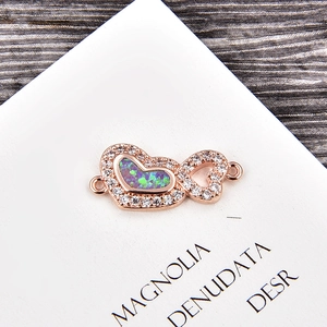 Vue macro d'un connecteur double cœur en opale rose doré pour création bijoux