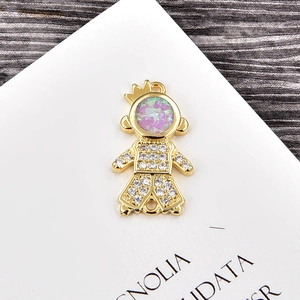 Macro shot of a gold-plated girl pendant charm with opal stone and sparkling crystals