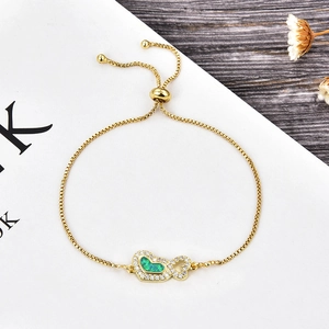 Détail d'un bracelet cœur doré ajustable avec opale verte et accents de zircons