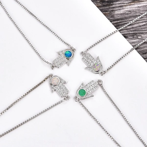 Makro-Detail von Hamsa-Hand-Verbindern mit bunten Opalsteinen und Zirkonia-Pavé