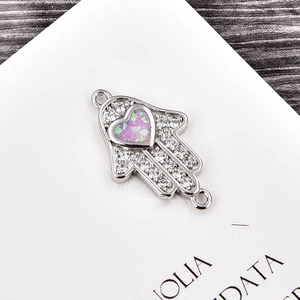 Makroaufnahme von Hamsa-Hand-Verbinder mit Herz-Opal und Zirkon für DIY-Schmuck