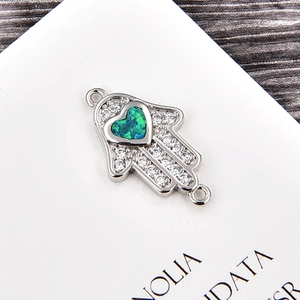 Makroaufnahme von Hamsa-Schmuckverbinder mit herzförmigem grünem Opal und Zirkonien