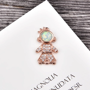 Macro shot of rose gold girl charm with white opal head and sparkling zircon connector
