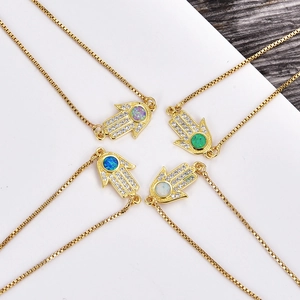 Detailansicht goldener Hamsa-Anhänger mit Opalsteinen in Blau, Grün und Lila sowie Zirkonien