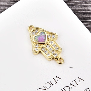 Makroaufnahme: Hamsa-Hand-Verbinder mit Zirkonia und herzförmigem Opal
