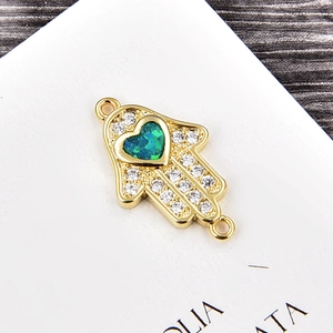 Makroansicht Hamsa-Hand-Verbinder mit grünem Herz-Opal und funkelnden Zirkonia-Steinen