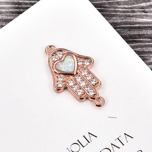 Makroaufnahme der Hamsa-Verbinder in Roségold mit Herz-Opal und Zirkonia für DIY-Schmuck