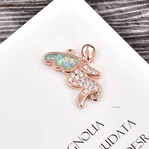Detalle macro del colgante de ángel en oro rosa con alas de ópalo y circonitas