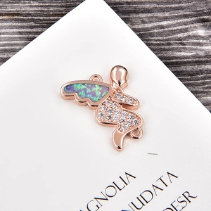 Vista macro de amuleto de ángel en oro rosa con alas de ópalo y circonitas para joyas