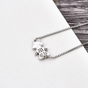 Close-up of a silver box chain bracelet featuring a delicate girl charm with hollow details