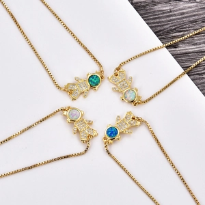 Close-up of gold plated boy and girl pendants with sparkling zircons and opal stones