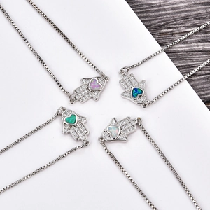 Details von Hamsa-Armbändern mit bunten herzförmigen Opalen und Zirkonia-Verzierungen