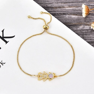 Detail of adjustable gold opal bracelet with a sparkling zircon-studded figure
