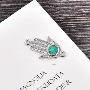 Makroaufnahme von Hamsa-Verbinder mit grünem Opal und funkelnden weißen Zirkonia