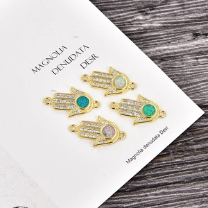 Makroaufnahme von Hamsa-Hand-Verbindern mit bunten Opalen und Zirkonia-Besatz