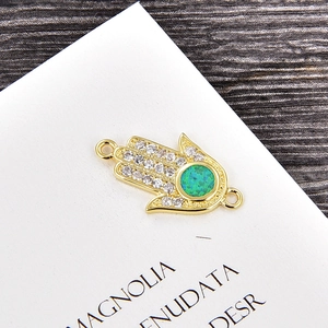 Detailansicht Goldene Hamsa-Hand Verbinder mit Kristallen und grünem Opal-Stein