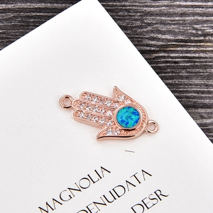 Makroaufnahme von Hamsa Hand Anhänger in Roségold mit blauem Opal und weißen Zirkonia