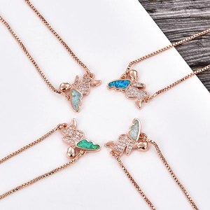Vista detallada de collares de ángel en oro rosa con alas de ópalo y circonitas