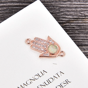 Makroaufnahme von Hamsa-Hand-Verbinder in Roségold mit Zirkonia und Opal-Zentrum