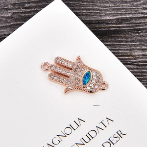 Detalle del dije Mano de Fátima en oro rosa con ojo de opalo azul y circones blancos