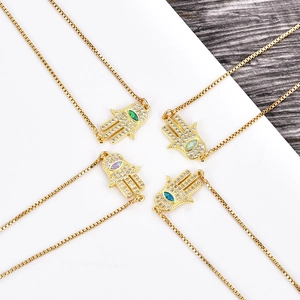 Detalle de los colgantes de mano de Hamsa con cadenas de caja y gemas de colores