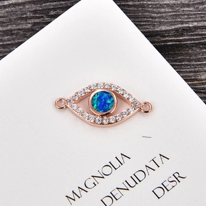 Makrodetail eines roségoldenen Evil-Eye-Anhängers mit blauem Opal und Zirkon-Inlay