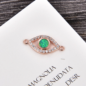 Makroaufnahme von Evil Eye Anhänger in Roségold mit grünem Stein und Zirkonia Besatz