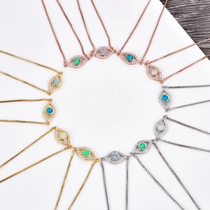 Detailansicht von Evil Eye Anhängern in Gold und Silber mit Zirkon- und Opalinlays