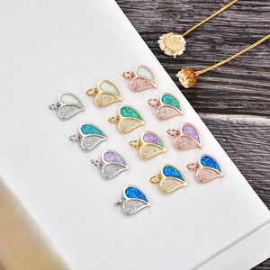 Collection de pendentifs cœur en opale et zircons colorés sur socle en marbre