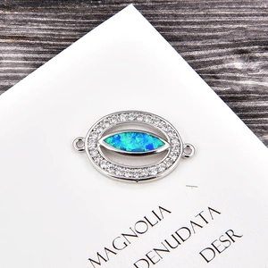 Détail d'un pendentif œil en opale bleue et zircons blancs sur support argenté poli