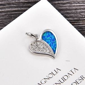 Détail macro du pendentif cœur avec zircons blancs et pierres d'opale de feu bleues