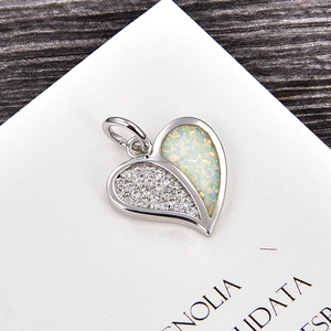 Détail macro du pendentif en forme de cœur avec pavé de zircons et incrustation d'opale