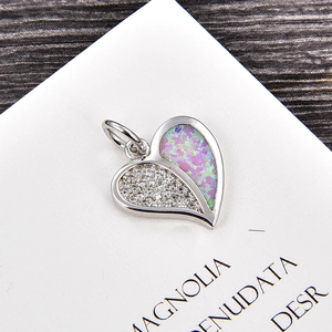 Détail macro du pendentif cœur avec zircone et incrustation opale sur bois élégant