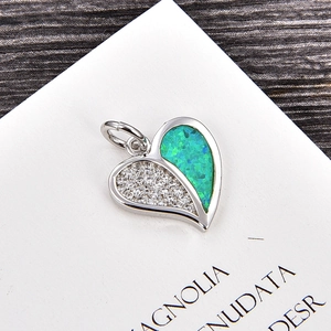 Vue détaillée du pendentif cœur avec zircons blancs et incrustation d'opale bleu-vert
