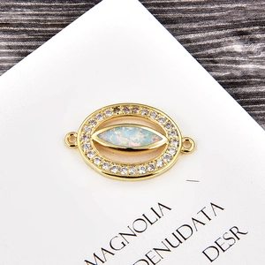 Détail macro du charm œil maléfique plaqué or avec opale et sertissage de zircons