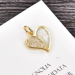 Macro d'un pendentif cœur avec pavé de zircons blancs et opale en plaqué or jaune