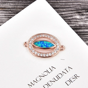 Détail du connecteur oeil en or rose avec opale bleue et zircons pour bracelet