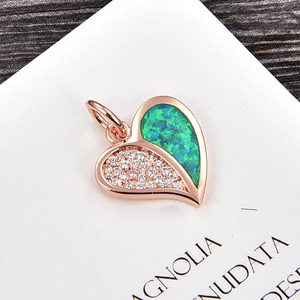 Pendentif cœur en or rose avec opale verte et zircons blancs sur une carte