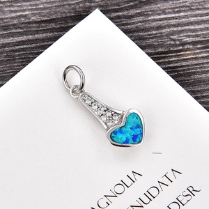 Détail macro du pendentif cœur en argent avec opale bleue et pierres de zircon blanc
