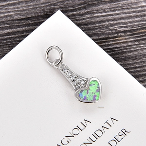 Détail macro du pendentif en cœur avec incrustation d'opale et zircons blancs polis