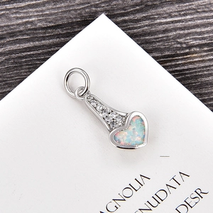 Gros plan du pendentif cœur argenté avec opale et bélière pavée de zircons blancs