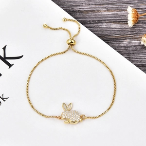 Dettaglio del bracciale con ciondolo a coniglio dorato, orecchie in opale e zirconi