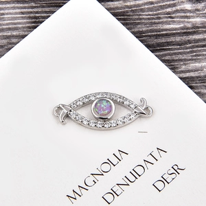 Vue macro d'un connecteur en forme d'œil en argent avec opale violette et oxydes de zirconium