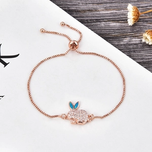 Dettaglio del bracciale con coniglio in oro rosa con orecchie in opale blu e zirconi