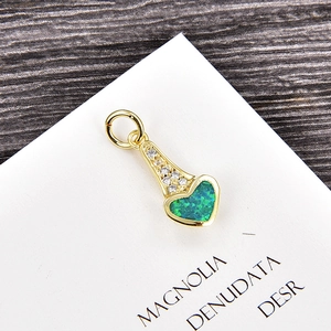 Détail macro du pendentif coeur en opale verte et oxydes de zirconium sur métal doré
