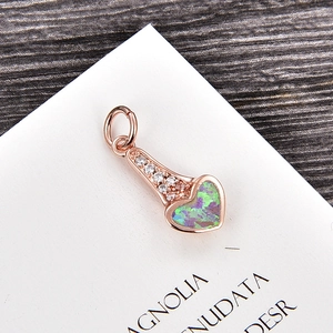 Détail macro d'un pendentif cœur en or rose avec opale et zircone pour colliers
