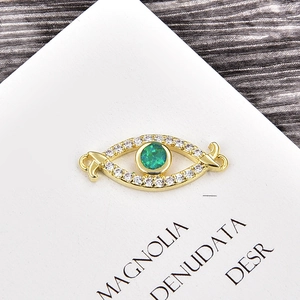 Gros plan détaillé d'un connecteur de bijoux en œil d'or 18 carats avec zircon vert